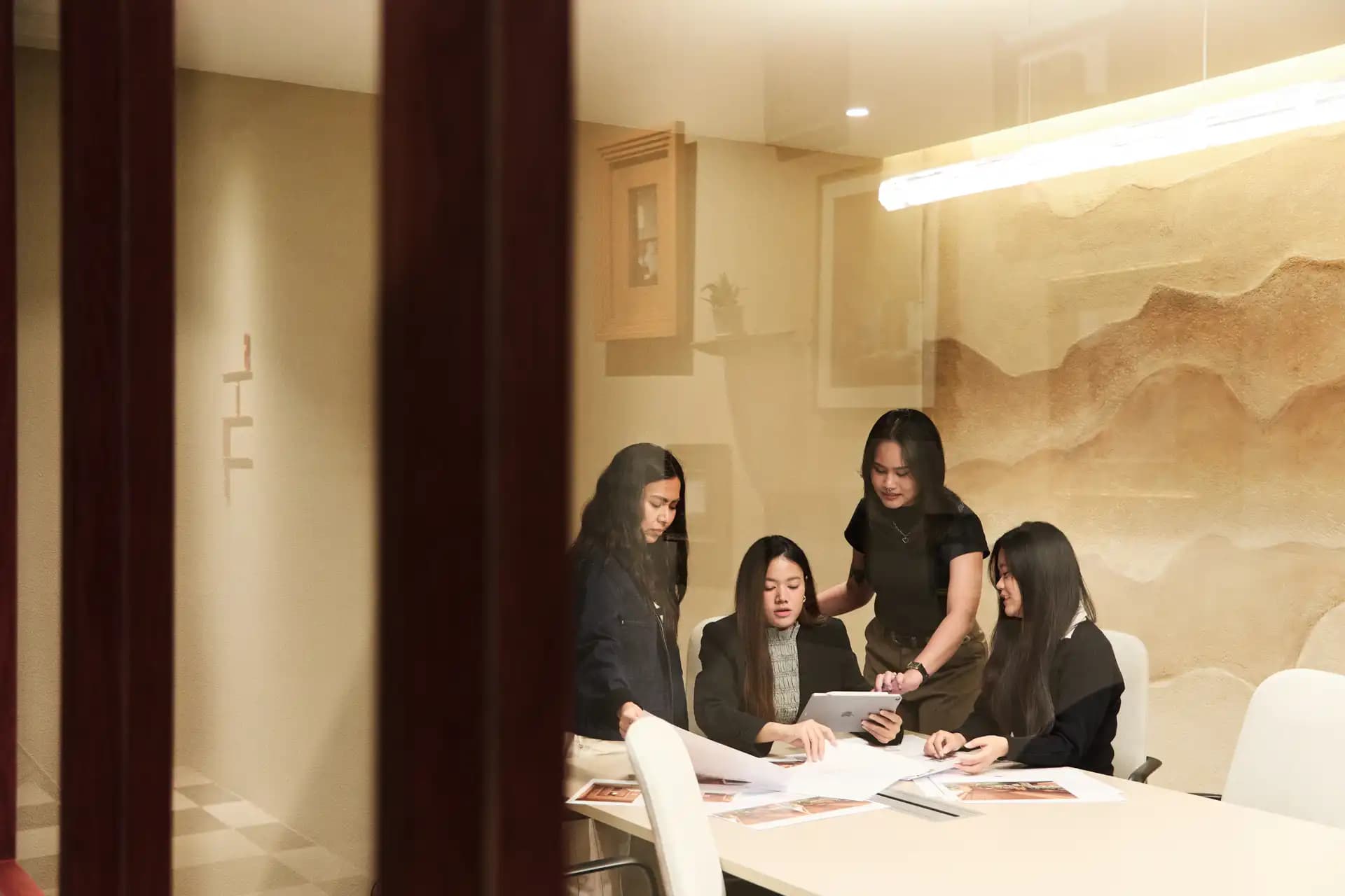 Siwa design team discussing project details and architectural drawings around a meeting table