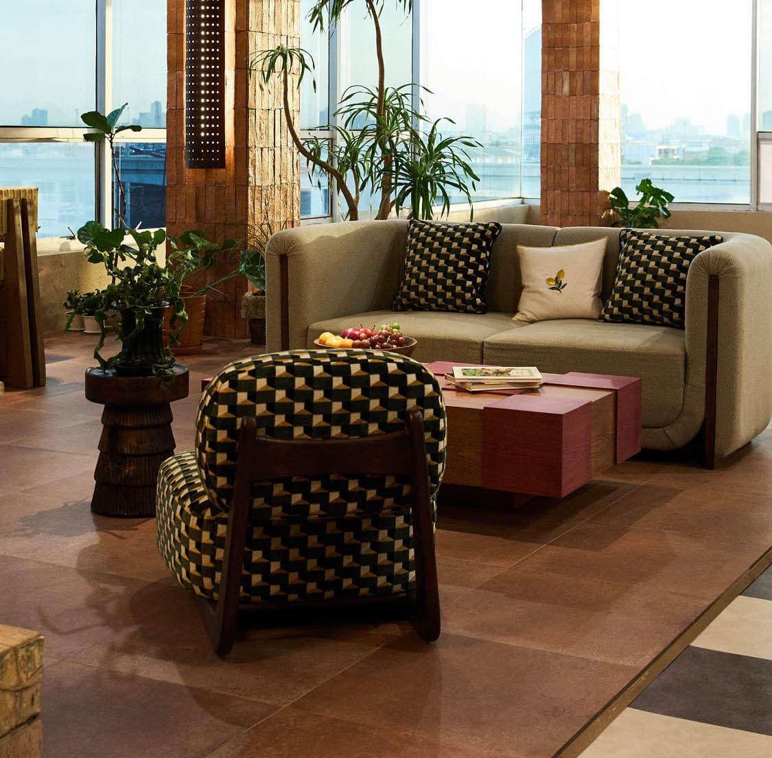 Patterned lounge seating surrounded by plants and city views