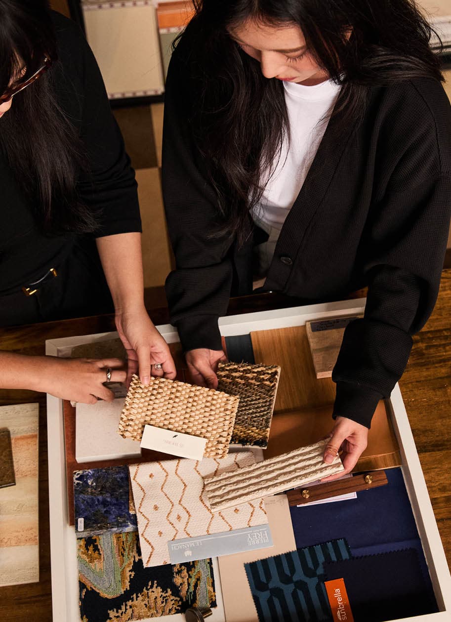Hands selecting woven textile and fabric samples
