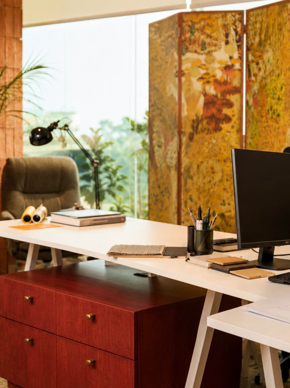 Creative director desk framed by a botanical folding screen