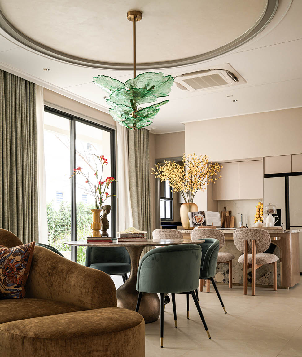 Living and dining area with green glass pendant and warm furnishings